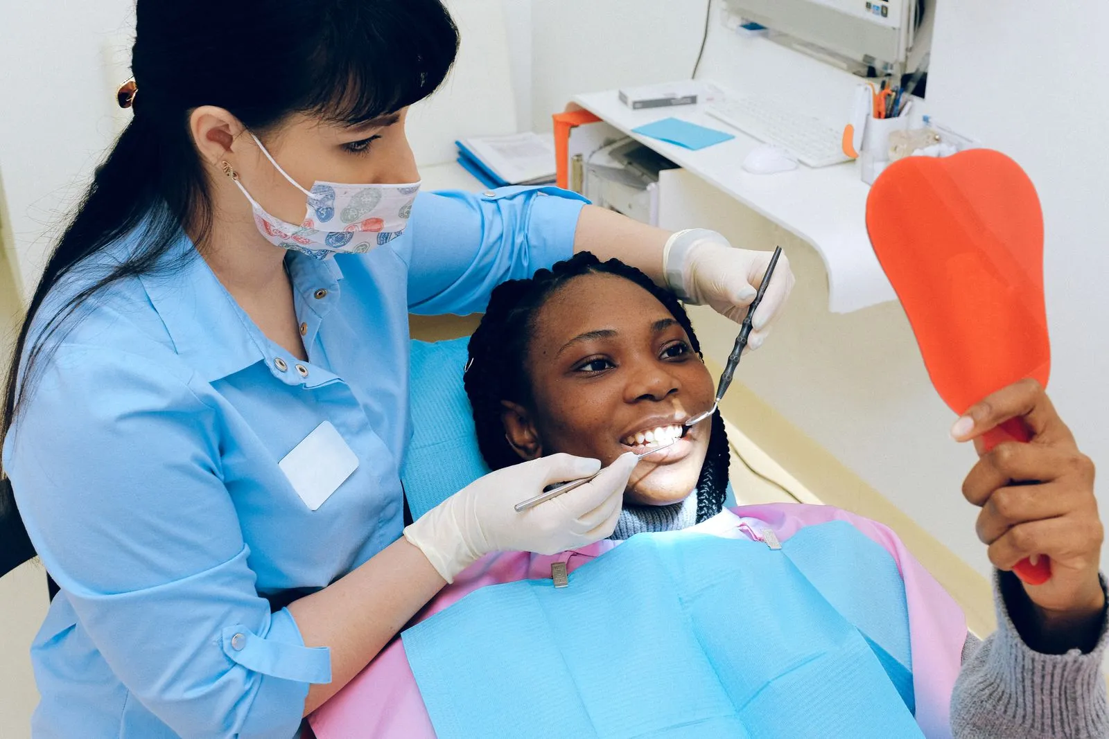 Revisión de los dientes de una mujer con un espejo dental